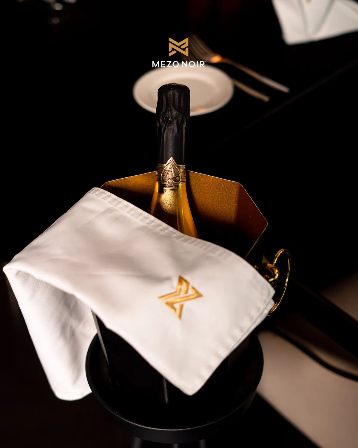 A bottle of Armand de Brignac on ice in a gold bucket