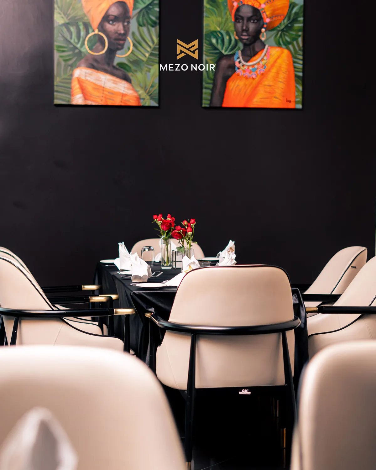 Cream dining chairs under two portraits in the dining room