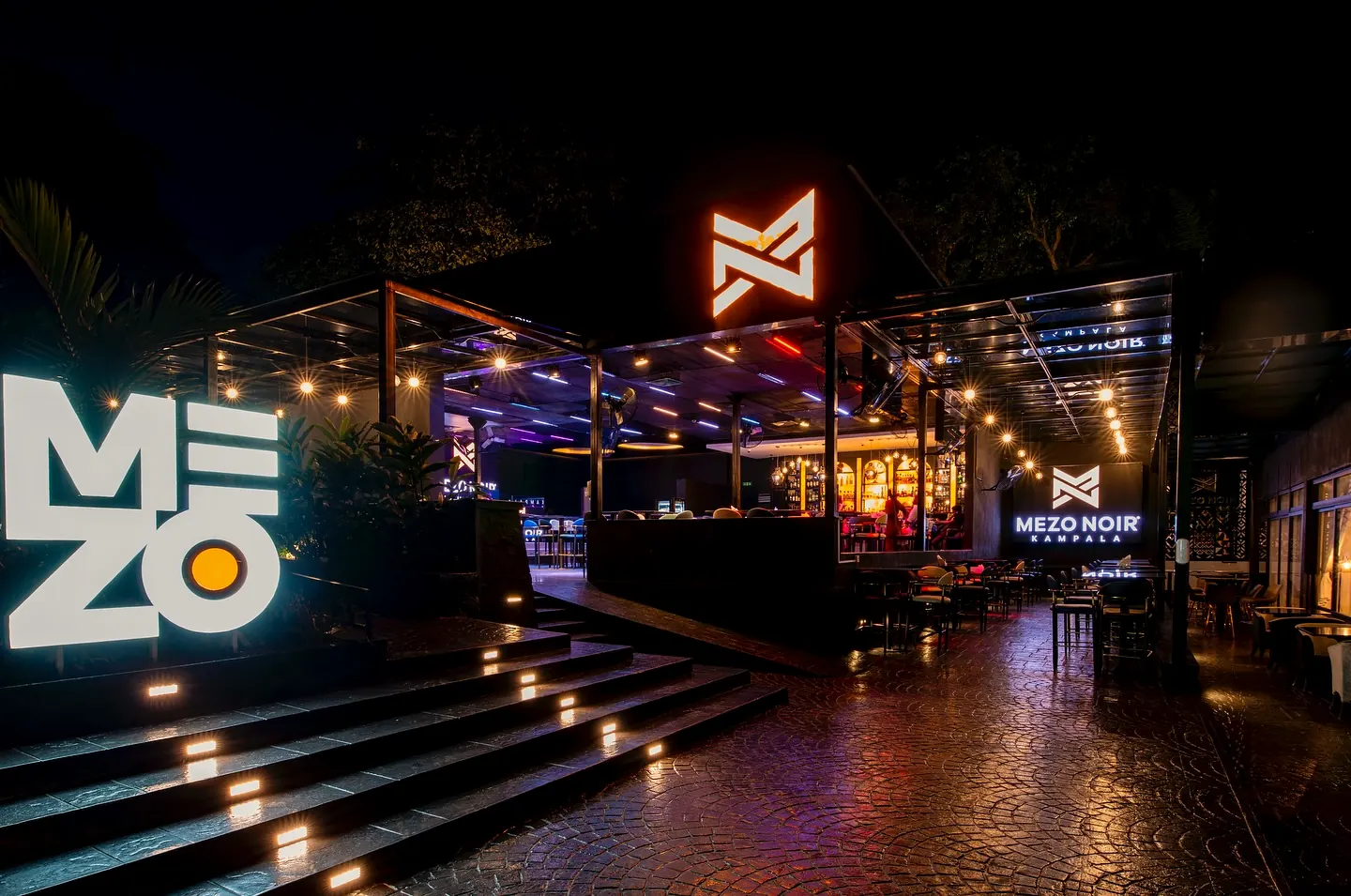 The courtyard at night with the lit Mezo sign